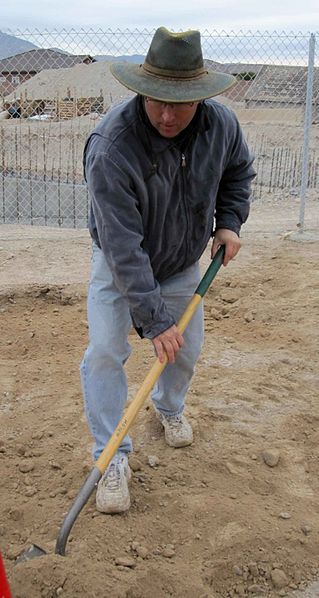 Man shoveling dirt - a rite of passage into manhood is diligence at our father son bonding retreat